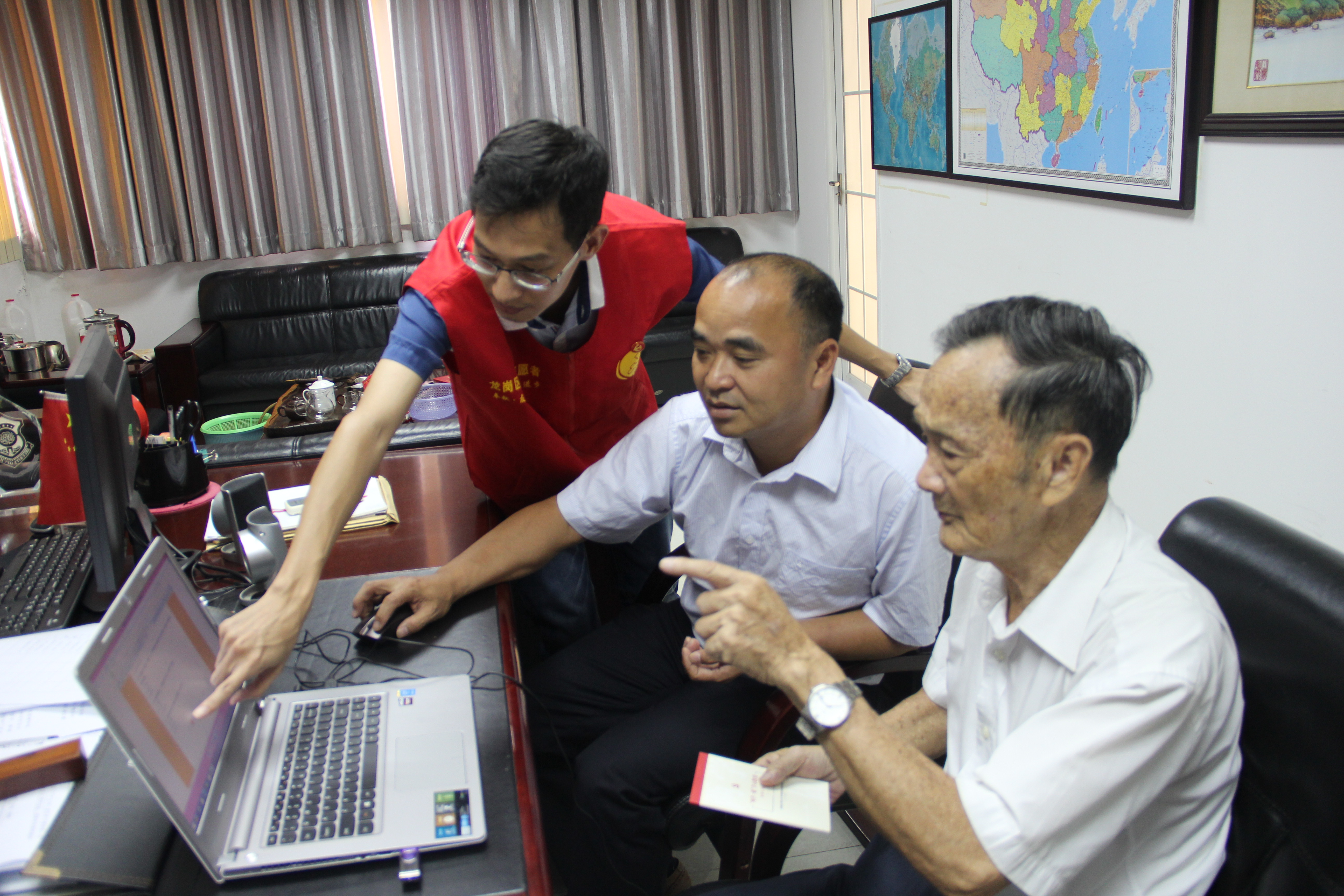 图为：2016年7月12日，丹竹头社区党委书记罗志斌同志现场指导退休老党员完成“两学一做”网上考学活动
